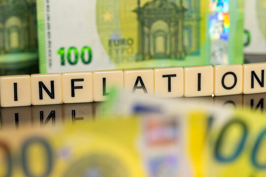 Symbolbild Inflation: Eurobanknoten und Buchstabenwürfel die das Wort Inflation anzeigen