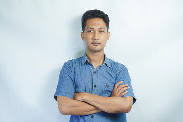 Smiling confident asian young man standing with arms crossed