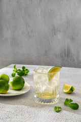 Brazilian traditional caipirinha cocktail made with lime, cachaça and sugar. Fresh summer caipirinha cocktail with green fruit lime on table