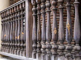 Fototapeta na wymiar Traditional old wooden railings decorative pattern at old stone house in Geotgia