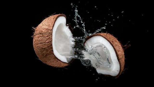 Cracked coconut with splashing water, super slow motion filmed on high speed cinematic camera at 1000 fps.