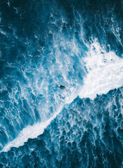 Fototapeta na wymiar Increíble imagen aérea de un surfero desafiando las olas del mar, mostrando su destreza y pasión por el deporte acuático en un entorno paradisíaco.
