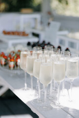 Glasses with champagne are on the table at wedding banquet.