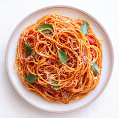 Spaghetti pasta with tomato sauce, basil and Parmesan cheese. Italian cuisine. Vegetarian food.