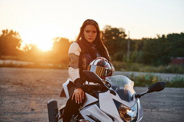 Beautiful woman is with motorcycle outdoors