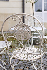 Victorian-style iron white chair in outdoor cafe