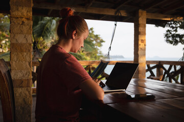Digital nomad women. Remote freelance worker in tropics.