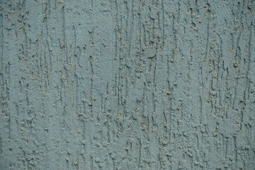 Closeup of dusty faded blue wall with stucco worm finish