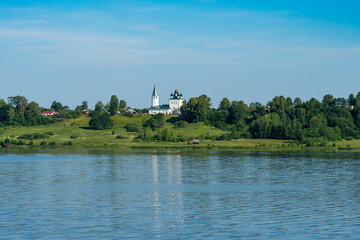Yaroslavl region, Russia, July 5, 2023.White-stone old temple on the river bank.