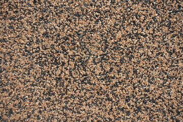 Macro of wall with coarse brown and black pebbledash finish