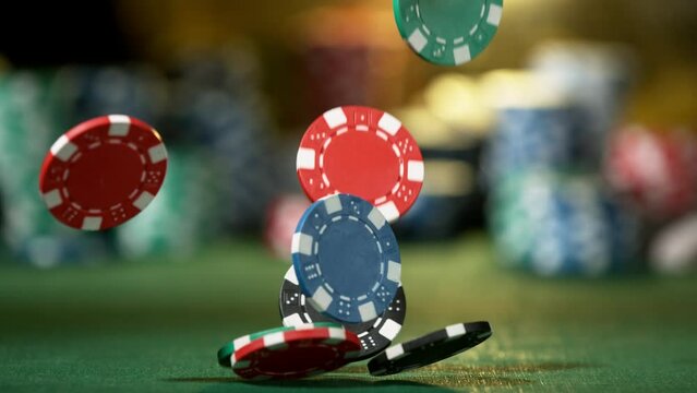Poker chips falling on casino table in super slow motion, filmed on high speed cinema camera at 1000 fps. Gambling background.