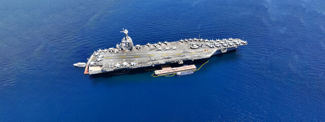 Aerial drone ultra wide panoramic photo with copy space of latest technology nuclear powered aircraft carrier anchored in deep blue open ocean sea