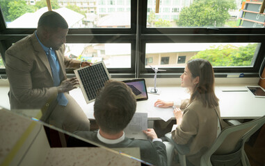 Obraz premium High angle view of diverse group of business people working together in office, Brainstorming on how to use natural energy from wind and sunlight to offer customers.