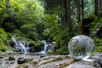 ガラスの地球儀と美しい渓流　地球環境に関するイメージ　Glass globe and beautiful waterfall