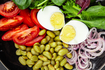 edamame bean salad vegetables, tomato, boiled egg, salad dressing ready to eat healthy appetizer meal food snack on the table copy space food background