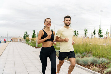 Personal fitness trainer and client fitness training in the fresh air.  Friends a woman and a man are friends in sportswear for sports.   People use fitness watches.