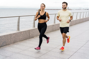 Friends are fitness people who train together.  Runners couple training full-length running.  Using smart watches for fitness, sportswear and running shoes.