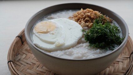 Top view table a bowl of porridge with egg on top. Asian breakfast.
