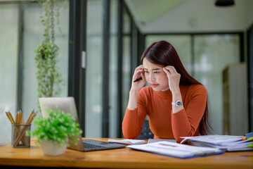 Business woman sitting at work stressed , out working hard Feeling stressed out and dizzy from a job