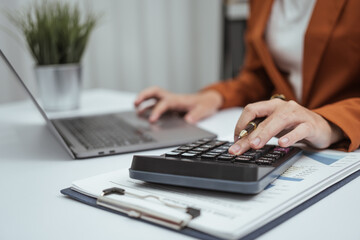 Close up hands of woman in brown formal suit checking bills, taxes, bank account balance, using calculator, Personal Checking, Empower Checking, Personal Savings, Certificates, IRAs, Money Market