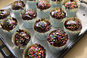 Chocolate cupcakes with small colorful candies, home baking