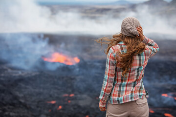 A tourist on the background of a volcanic eruption in Iceland 2023 - 642076850