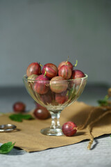 Ripe red gooseberries in a vintage vase. Vintage rustic rustic concept