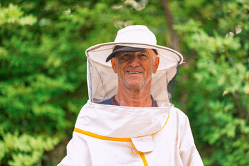 A beekeeper in a protective suit on the apiary. Eco apiary in nature. Beekeeping. Man and nature.
