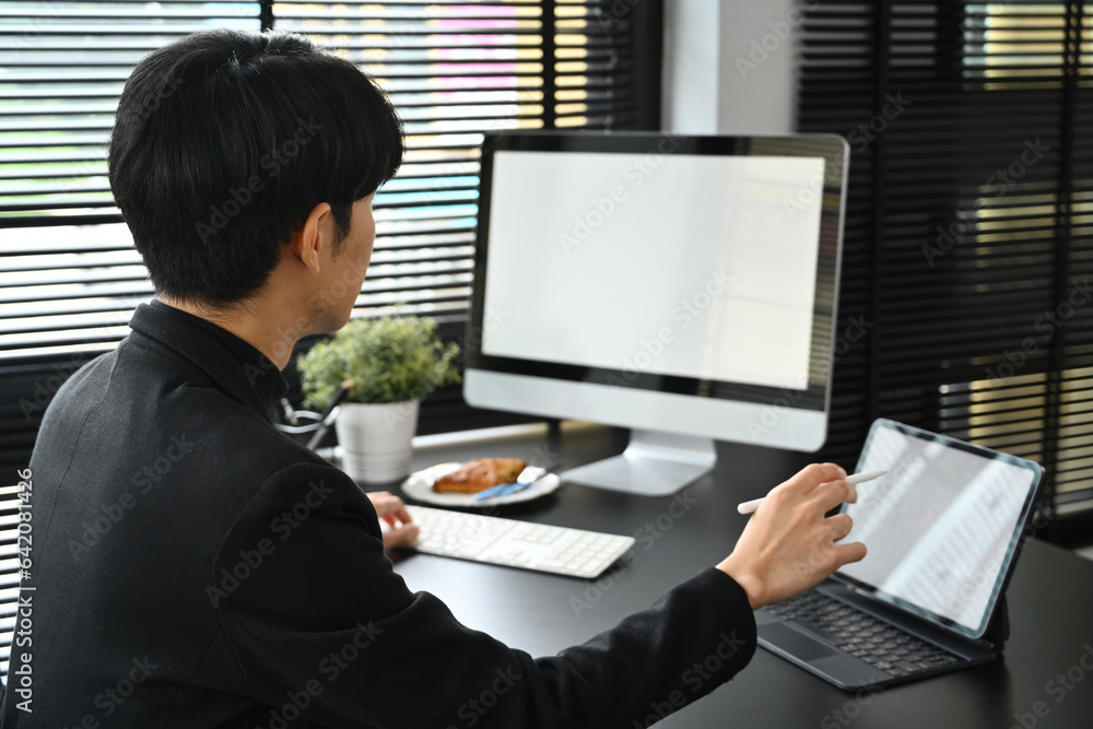 Aufkleber back view image of a young creative designer working with computer and digital tablet, designer and 