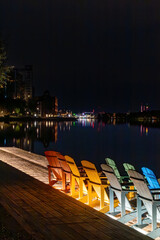 Fototapeta na wymiar Stockholm, Sweden Colorful beach chairs at night adorn a waterfront bar in the Nacka Strand district.