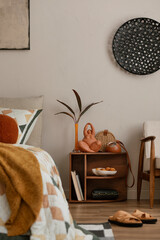 Stylish composition of orange bedroom interior with mock up poster frame, orange bedding, wooden...