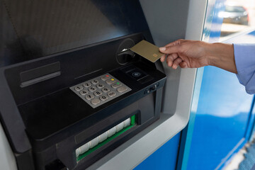 female hand puts a bank card into an ATM
