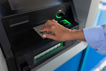close-up of a woman entering a pin code at an ATM