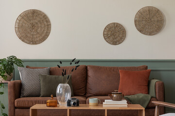Interior design of cozy living room interior with wooden coffee table, brown sofa, wooden partition...