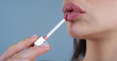 Close up woman applying red lipstick on lips. Sexy girl applied lipstick. Red lips lipstick make up. Putting lipstick on lips. - obrazy, fototapety, plakaty
