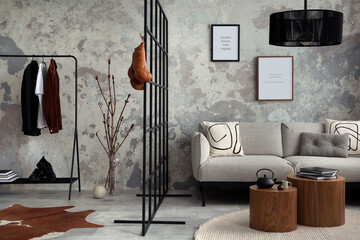 Sophisticated composition of modern living room with design sofa, lamp, carpet, clothes rack , decoration and personal accessories. Wabi sabi concrete wall. Minimalist home decor. Template.