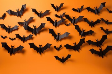 Obraz premium black paper bats fly on orange background