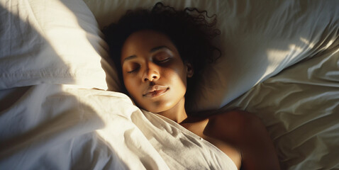Black woman sleeping in bed with sunlight