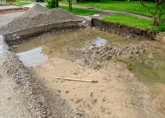 Unfinished Street Repair/Drainage Project with Standing Water and Mud in Dug Out Section of a...
