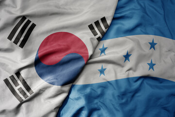 big waving national colorful flag of south korea and national flag of honduras .