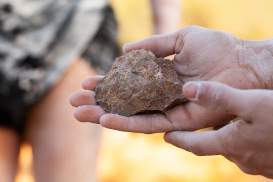 Axe head carved stone held in hand of aboriginal man