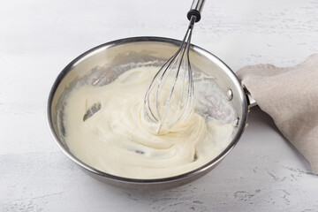 Making cheese sauce for pasta. Add milk and mix until creamy. DIY step by step step 6