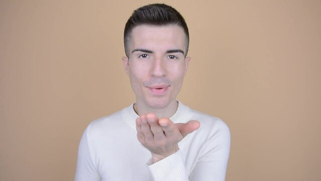 Man sends a kiss to the viewer. Blowing a kiss. Concept of love, Valentine's Day, romance. Young handsome caucasian, isolated background.