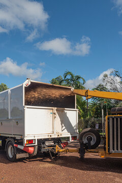 wood chipper chipping wood into truck
