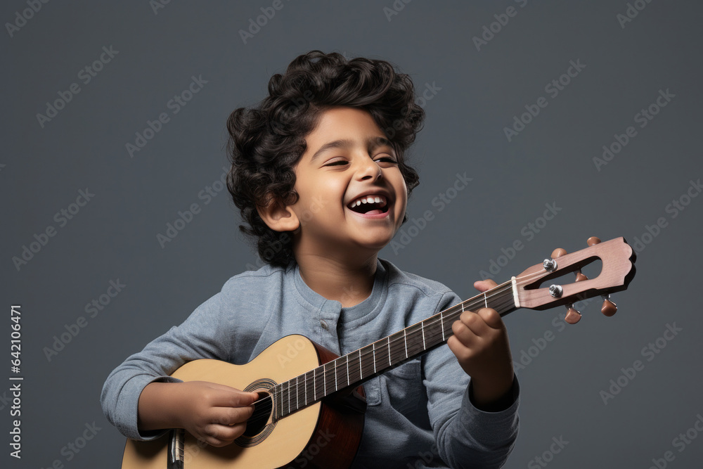 Wall mural happy indian kid playing guitar, a musical instrument