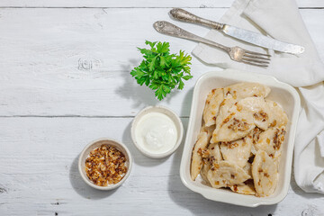 Dumplings, filled with cabbage. Fried onion, fresh sour cream. Traditional Ukrainian dish