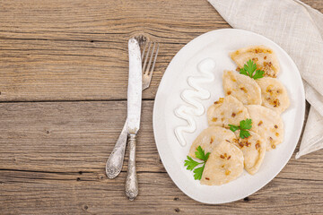 Dumplings, filled with cabbage. Fried onion, fresh sour cream. Traditional Ukrainian dish