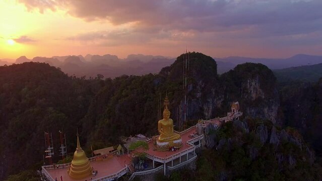 .Aerial view colorful clouds at sunset behind the Golden  Buddha on the mountain peak. .The clouds, illuminated by the setting sun, .create a beautiful and serene atmosphere. Sky texture..