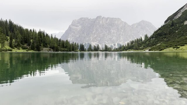 one duck swims across the frame in the rain on lake Seebensee