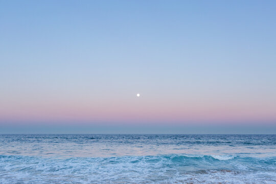 Full moon over blue sea water in pastel sky - Powered by Adobe
